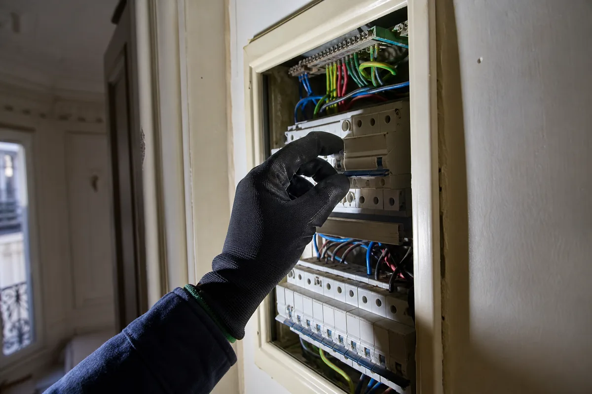 Tableau électrique ouvert dans un appartement parisien avec une manette de différentiel abaissée