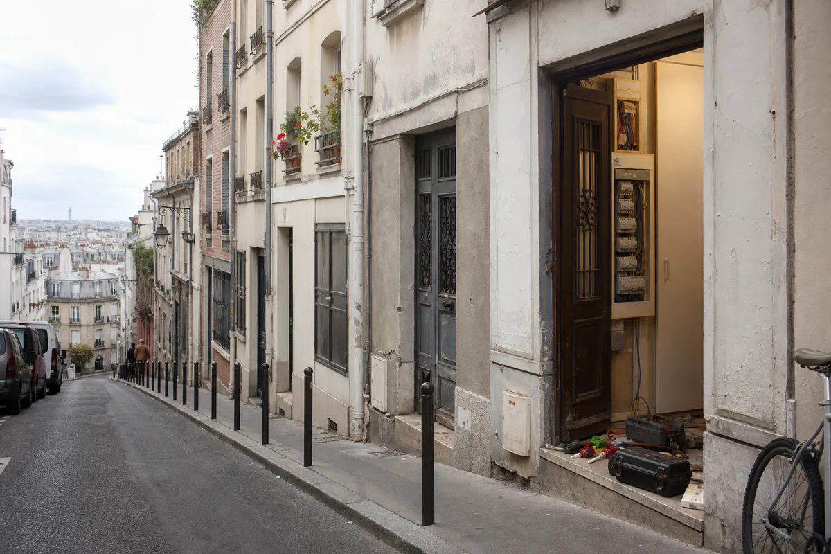 Rue en pente de Ménilmontant bordée d&rsquo;immeubles faubouriens anciens aux façades étroites
